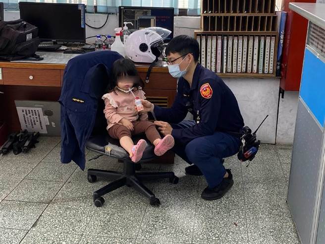 3岁小女童趁着妈妈不注意，自己偷偷打开家门溜出门到公园玩耍，被热心民眾发现通报员警带回。单身暖警靠1瓶多多，让女童乖乖坐在椅子上等候。（警方提供／谢琼云台中传真）