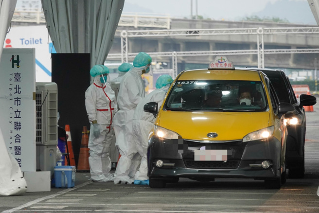 台湾疫情不断升温，医护人员在车窗边为民眾採检。（黄子明摄）