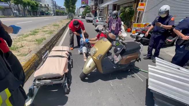 女機車騎士被倒塌的工地圍籬砸到受傷，消防人員救護。（讀者提供／廖素慧嘉市傳真）