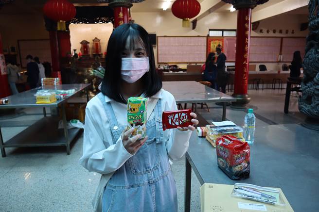 张姓学生因为想考日文系，前来文林阁拜拜时特别选用日本考生常用的开运饼乾祈福。（邱立雅摄）