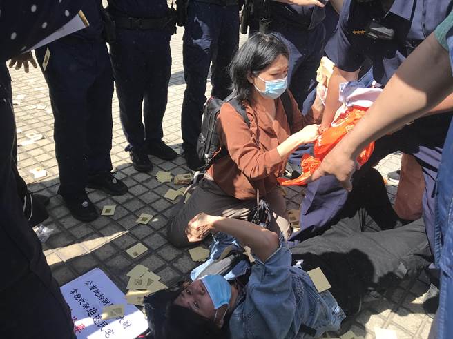 屏东火车站周边道路拓宽案波折不断，反迁民眾26日又到县府举布条还撒冥纸，期间与警方爆发激烈拉扯。（谢佳潾摄）