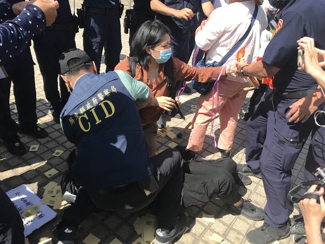 屏东火车站周边道路拓宽案波折不断，反迁民眾26日又到县府举布条还撒冥纸，期间与警方爆发激烈拉扯。（谢佳潾摄）