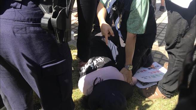 屏东火车站周边道路拓宽案波折不断，反迁民眾26日又到县府举布条还撒冥纸，期间与警方爆发激烈拉扯。（谢佳潾摄）