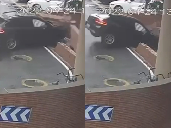 黑色保时捷从地下停车场驶出后右转，没想到驾驶疑似恍神「转过头」直接衝向停车场水泥墙，当场撞出1个大洞，保时捷随之垂直坠落「回到停车场」。（翻摄自脸书「记者爆料网」）