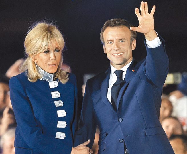 24日晚間，法國總統馬克宏在巴黎市中心的戰神廣場舉行慶祝勝選集會，偕夫人布莉姬登台。（路透）
