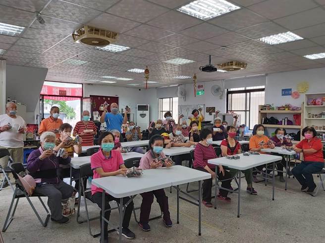 新生活促进会石门馨窝照顾关怀据点长辈拿到御饭糰既开心又舍不得吃。（新北市社会局提供）