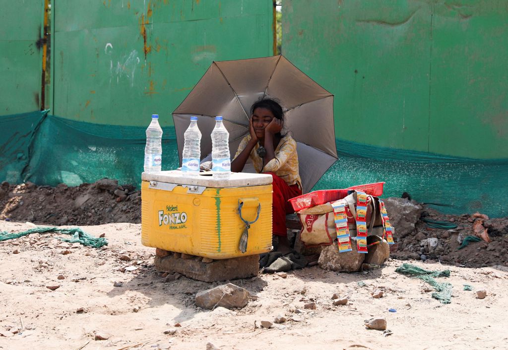 一个女孩大热天在路边卖水（图／路透）(photo:ChinaTimes)