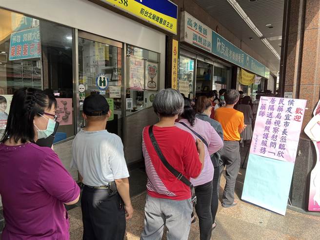 藥局一早即出現購買快篩試劑人潮。（王揚傑攝）