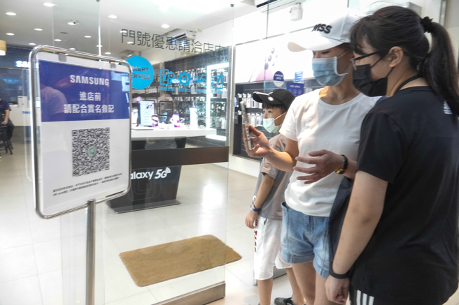民眾进入店家前扫实联制，这项规定今天退场。（黄子明摄）