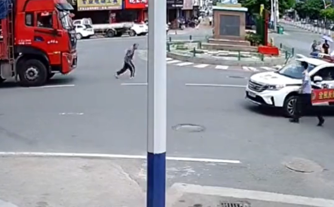 男子倒在地面上沒多久後，見到警察到場，立刻像沒事般站起身，爬腿狂奔。（翻攝自微博）