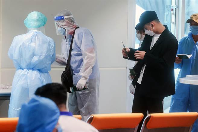 央流行疫情指挥中心因入境隔离採检旅客阳性偏高，自3月22日起实施长程线班机落地採检，现今因本土疫情持续暴增，28日本土案例更已突破万人，已经是入境旅客阳性反应的近100倍，桃园机场航空联席会表示，目前本土与境外移入确诊比例悬殊，是否应该检讨取消已经不符当初落地採检政策的规定，让机场运作恢復正常。图为桃园机场落地採检入境旅客在候机室等候採检。（非新闻当事人）（陈麒全摄）