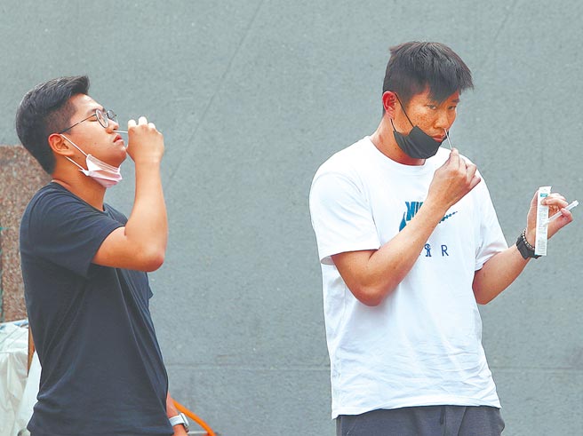 中职味全龙队27日传出6位队职员在自主快筛时呈现阳性反应。图为牛棚投手教练林恩宇（右）自行快筛。（陈怡诚摄）