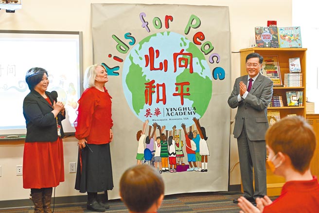 當地時間4月25日，中國駐美大使秦剛訪問位於明州明尼阿波利斯市的中文沉浸式特許學校英華學院。圖為英華學院校長包善容（中）向秦剛（右）贈送學生製作的“心向和平”（Kids for Peace）海報。 （中新社）