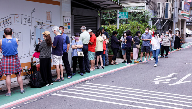 「快筛实名制」28日正式上路，每次可凭健保卡或居留证就能到药局买一组5入500元的快筛试剂，民眾一早便前往药局排队抢购。（罗永铭摄）