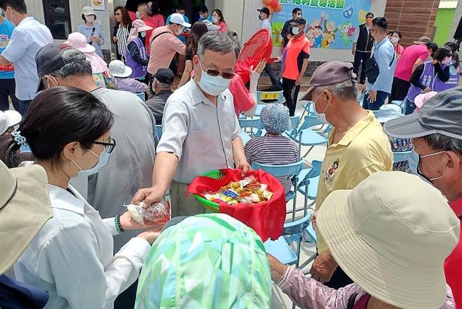 賴峰偉依循古禮將炸棗、土豆粿、黑糖糕、麻吉點心分送參加活動的民眾。（澎湖縣政府提供）