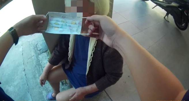 高龄阿嬷未戴口罩独坐骑楼，员警赶紧提供口罩，运用手机拍照寻人，顺利送返家。（民眾提供／卢金足台中传真）