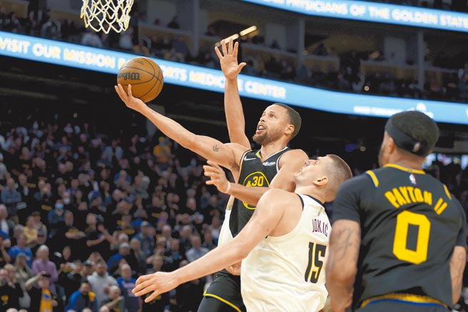 勇士后卫柯瑞（左）突破金块重重防守，切入右手挑篮得分。（美联社）