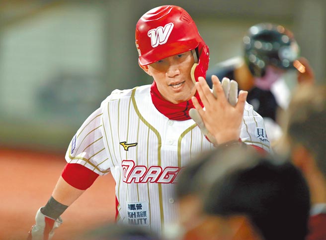 味全龍石翔宇2局下打出2分打點安打後，回本壘後與隊友擊掌慶賀。（鄭任南攝）