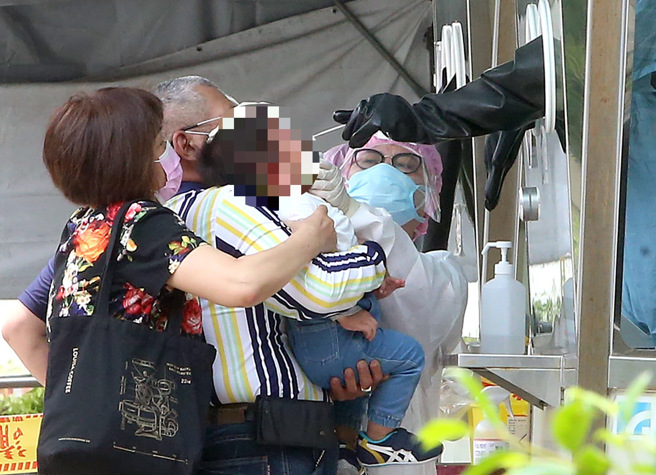 本土疫情炸鍋，家長帶著小朋友一起篩檢，確保安全。（趙雙傑攝）