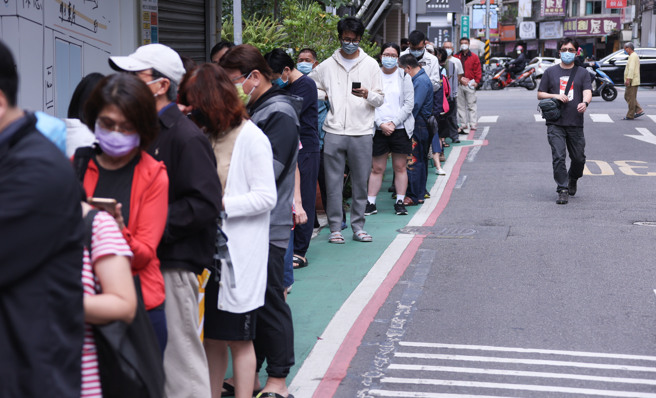 快筛实名制上路第3天适逢假日，半数药局不开门，不过仍可见大批民眾在有营业的药局门口排队抢买。（图／罗永铭摄）