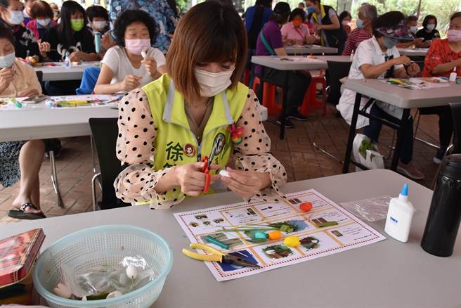 苗栗县农会30日举办母亲节手作蚕茧花活动，苗栗县议员徐筱菁认真地剪裁蚕茧。（谢明俊摄）