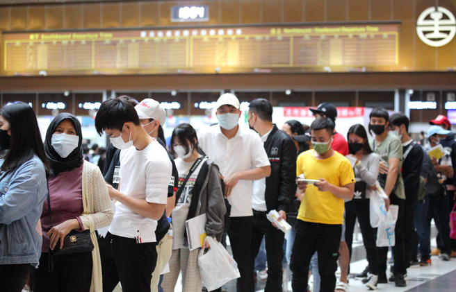 本土確診個案屢創新高，自28日起，連續3天確診數突破萬例。圖為台北車站接種站午後湧入排隊人潮，等待施打疫苗。（張鎧乙攝）