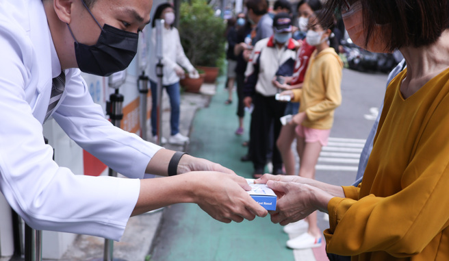 民眾抢购快筛试剂，药师选择户外贩售。（罗永铭摄）
