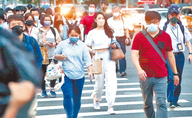 即将迈入夏天，不少民眾因长时间戴口罩，面临了痘痘恶化的问题，皮肤科医师提醒民眾尽量避免熬夜，把握11点前睡觉。图为下班时刻，民眾戴口罩经过路口。（郑任南摄）