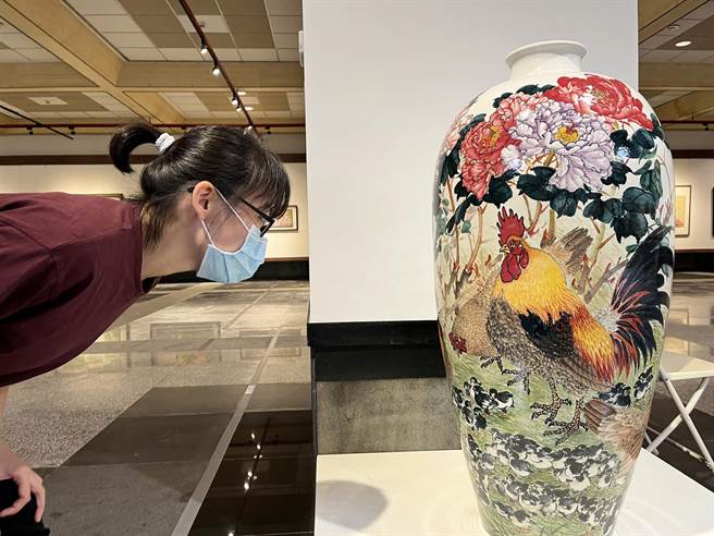 民眾仔细端详陈士侯的精细的陶艺彩绘。（港区艺术中心提供）