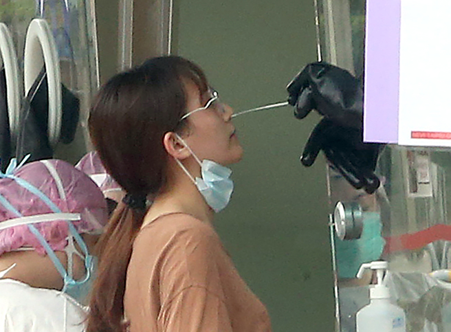 疫情升温，民眾涌入筛检站採检的画面。（本报系资料照）