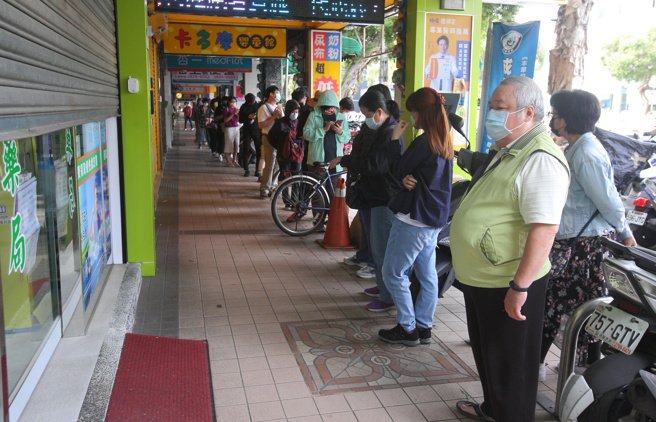 國內疫情升溫，快篩需求量也隨之增加，然而快篩實名制上路後亂象頻傳，重演當年的口罩之亂，讓網友相當不解。圖為民眾一早在藥局外等待開門購買快篩。（張鎧乙攝）