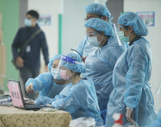 新冠肺炎疫苗日前開始為6-11歲學童接種，桃園市龜山區自強國小3日施打莫德納疫苗，負責疫苗施打的懷寧醫院醫護人員在施打前討論施打流程。(陳怡誠攝)