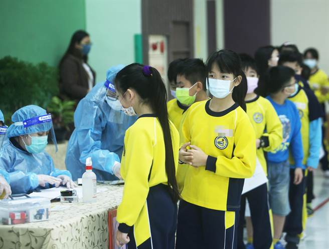 新冠肺炎疫苗日前開始為6-11歲學童接種，桃園市龜山區自強國小3日施打莫德納疫苗，預備接種疫苗的學童依序掛號。(陳怡誠攝)