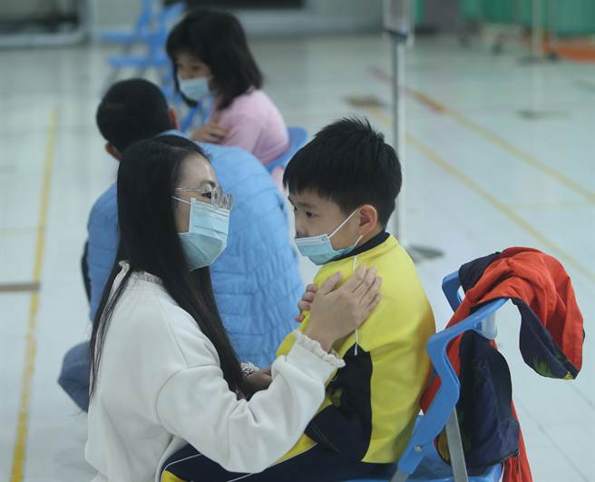 新冠肺炎疫苗日前開始為6-11歲學童接種，桃園市龜山區自強國小3日施打莫德納疫苗，一位低年級學童完成莫德納疫苗注射，老師趨前安撫該童的情緒。(陳怡誠攝)