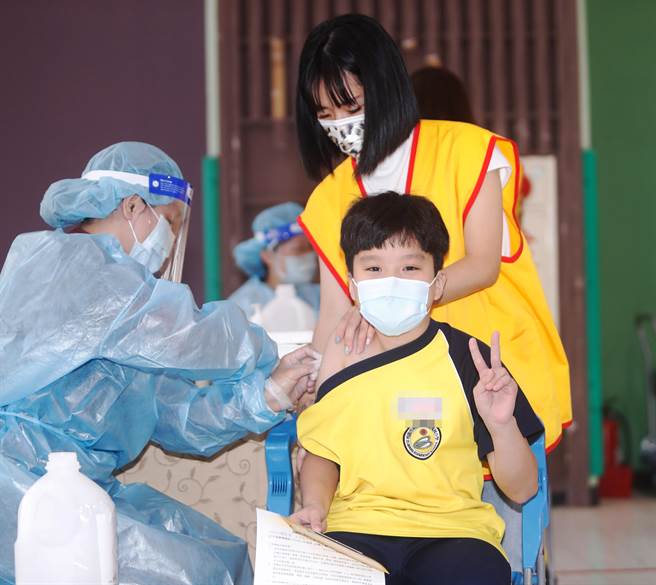 新冠肺炎疫苗日前開始為6-11歲學童接種，桃園市龜山區自強國小3日施打莫德納疫苗，一位高年級學童注射時比出勝利的手勢。(陳怡誠攝)