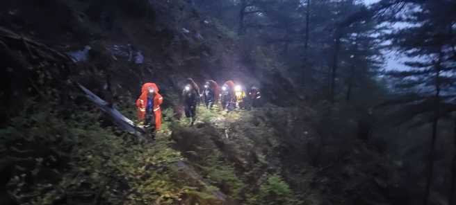 一名玉山志工在巡山时不幸坠落死亡，消防与协作冒雨背负运出大体。（南投县消防局提供）