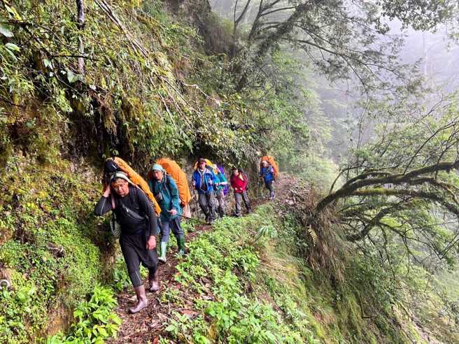 玉管处69岁黄姓保育志工在中央金矿山屋往杜鹃营地前进时不幸坠落丧生，消防与协作3日凌晨背负志工大体下山。（南投县消防局提供）