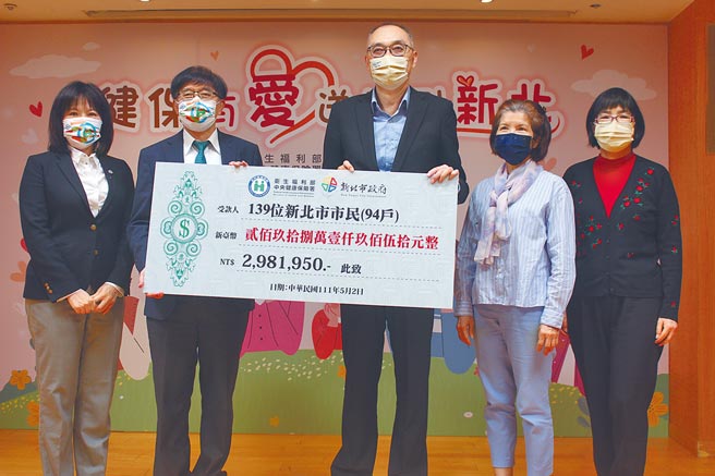 新北市去年有94户、139位弱势民眾透过健保署爱心基金协助，得以清偿健保费逾298万元，健保署长李伯璋（左二）颁发受赠支票给新北市副市长谢政达（右三）。（陈慰慈摄）