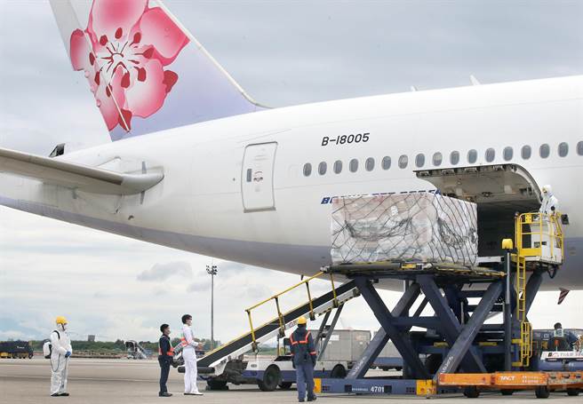 今年第6批採購的110.61萬劑莫德納疫苗昨（3）日運抵桃園機場，地勤人員從機艙卸下裝載疫苗的貨盤。（范揚光攝）