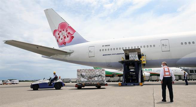 载运疫苗的班机停妥后，地勤人员从机舱卸下装载疫苗的货盘。（范扬光摄）