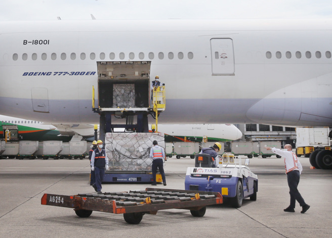 今年第7批111.55万剂莫德纳疫苗4日运抵桃园机场，载运疫苗的班机停妥后，地勤人员从机舱卸下装载疫苗的货盘。（范扬光摄）