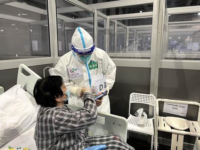 大陆援港医疗队人员于亚洲国际博览馆社区治疗设施照顾新冠轻症患者。（图／中新社）