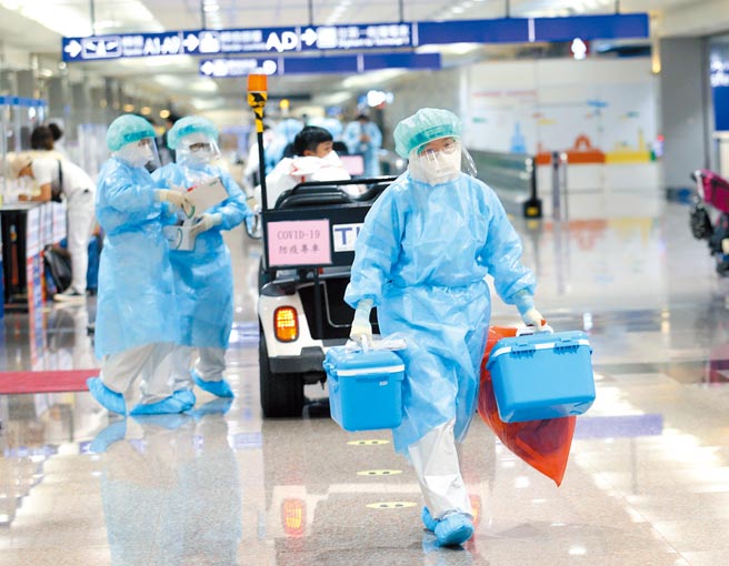 福又達公司遭質疑特權利益引發各界關注，衛福部長陳時中3日表示，桃機落地採檢「從頭到尾都跟福又達沒有關係」。在桃機入境管制區內，檢疫人員將旅客落地採檢的檢體送往檢體篩檢站檢驗。（范揚光攝）