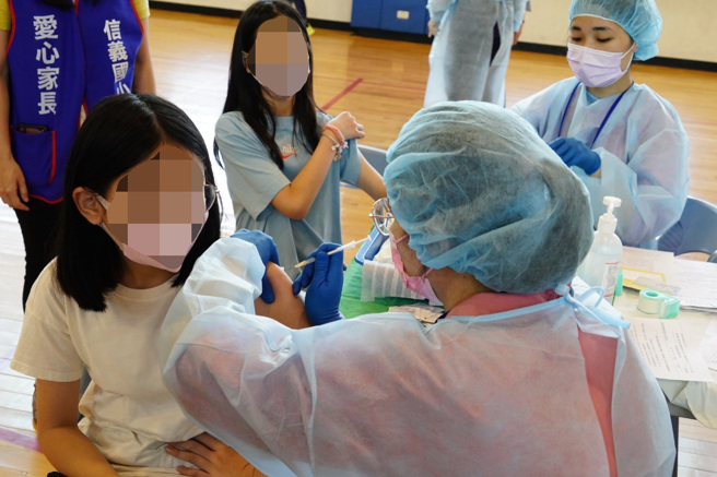 台北市啟動國小莫德納疫苗校園接種，信義國小5日800位學生有179位接種，約占全校22%，現場也由15位愛心志工及老師們一同陪伴孩子，多數小朋友接種完都說「不會痛」。（台北市政府提供）