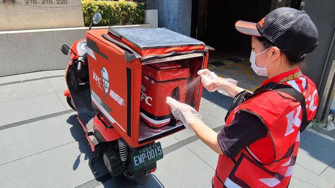 （肯德基「零接触外送」服务，外送员到达指定地点后，会先戴上一次性手套并喷上酒精消毒。图／肯德基）　　