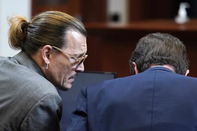 强尼戴普与前妻安柏赫德开庭，强尼戴普低头听着前妻指控，不时在便条纸上写字或轻声说话，传达给身边律师。（图／美联社）