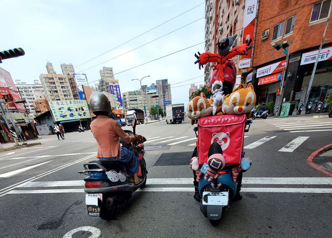 男子在台中某路口拍下娃娃挂满整车的外送车，他直呼「左转灯被挡住」，也让网友们摇头。（翻摄自脸书外送员的奇闻怪事）