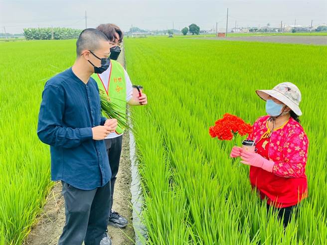 在西螺镇开咖啡车的年轻人赖柏村（前），专程帮阿仁送一束康乃馨和一杯咖啡给在田里工作的阿仁妈妈（右）。（创世基金会提供）