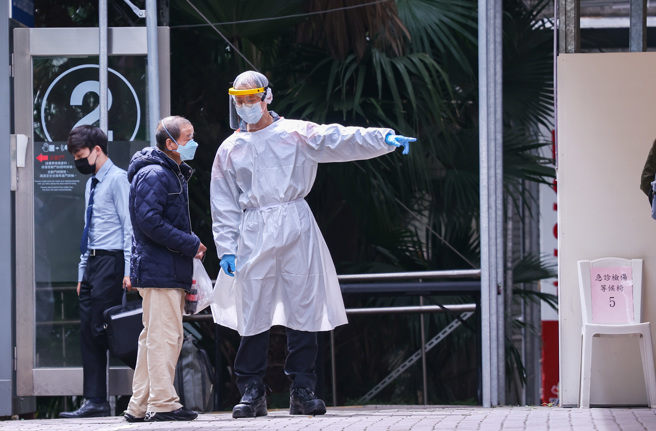 最近不少确诊者涌入急诊室，只为求医师开立诊断书，让医护人员相当头痛。图为急诊室外医护人员管制民眾进出。非新闻当事人。（罗永铭摄）