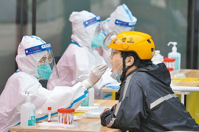 北京12个区展开第3轮区域核酸检测。图为在北京市朝阳区建外街道一处核酸检测站，来自北京安贞医院的医护人员为民眾进行核酸採样。 （新华社）